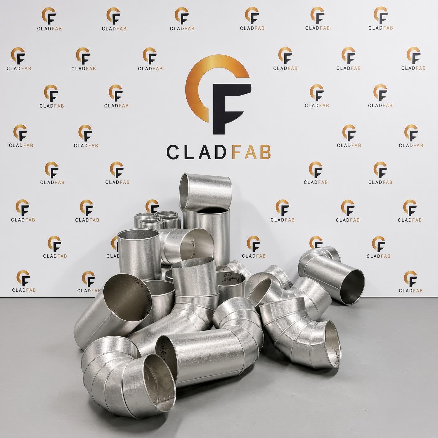 Radius bends and makeup pieces made by CladFab, against the CladFab backdrop