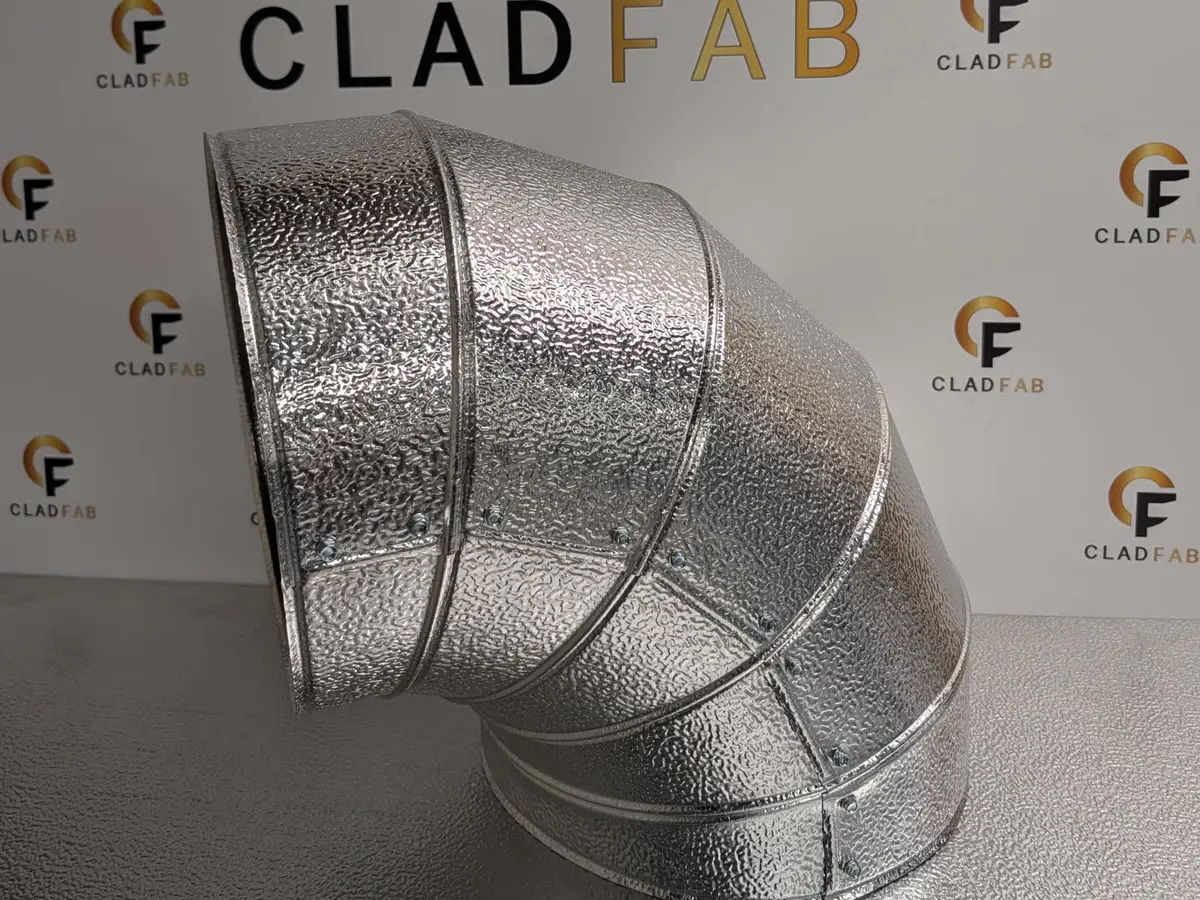 Stucco-embossed aluminium lobster bend fabricated by CladFab, in front of the CladFab logo wall